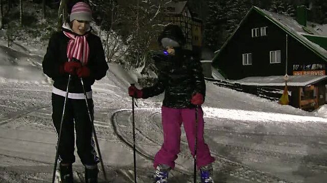 Playful teens Linda and Lilly are passionately kissing while skiing at night