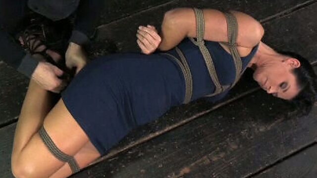 Hard Tied brunette wearing sexy dress lies on the floor