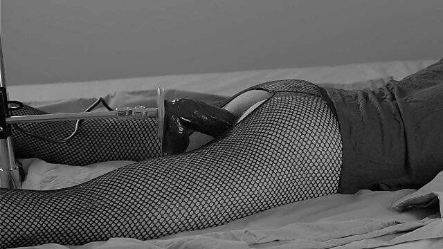 Slim brunette in fishnets enjoys a huge dildo inside